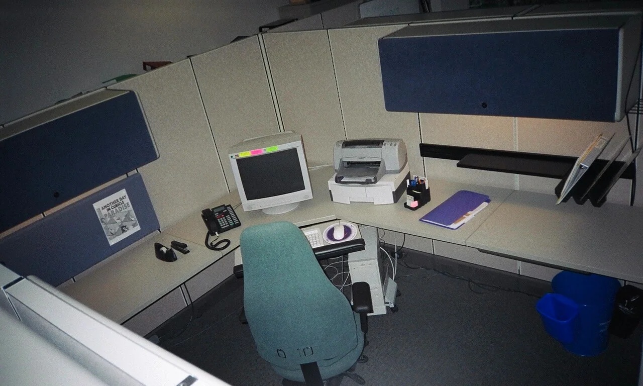 Clean office cubicle with desk, computer, and partitions